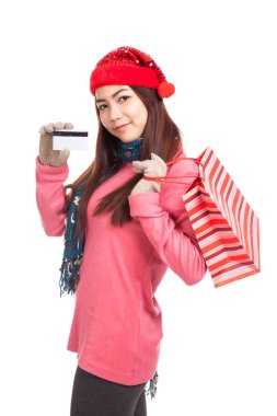 Asyalı kız kırmızı Noel şapka, kredi kartı ve alışveriş çantası