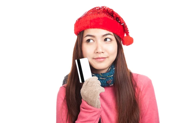 Asian girl with red christmas hat think and hold credit card — Stock Photo, Image