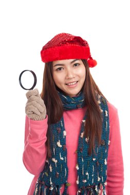 Asyalı kız kırmızı Noel şapka ve Büyüteç camı