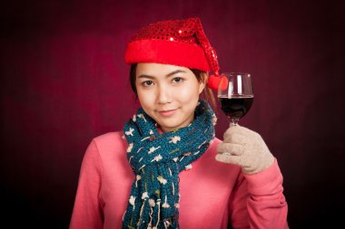 Bir bardak şarap ile kırmızı Noel şapka ile Asyalı kız