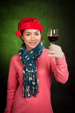 Bir bardak şarap ile kırmızı Noel şapka ile Asyalı kız
