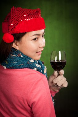 Bir bardak şarap ile kırmızı Noel şapka ile Asyalı kız