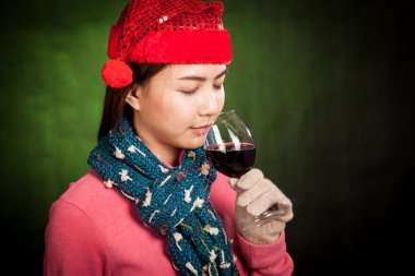 Asyalı kız kırmızı Noel şapka içki kırmızı şarap ile