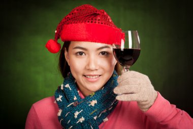 Bir bardak şarap ile kırmızı Noel şapka ile Asyalı kız