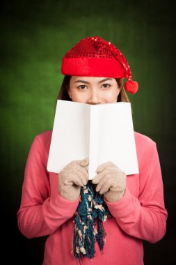Asyalı kız kırmızı Noel şapka ile bir kitap okumak