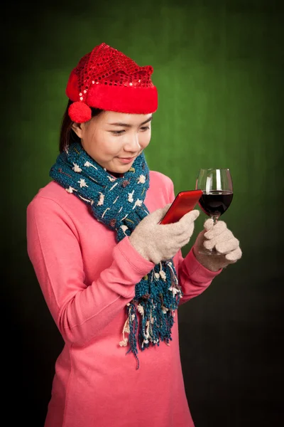 Asyalı kız Noel şapka, şarap ve cep telefonu ile — Stok fotoğraf