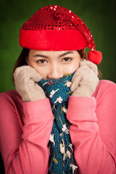 Asiatisk tjej med röd jul hatt känner sig kall — Stockfoto