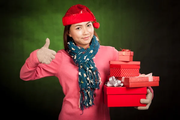 Aziatisch meisje duimen omhoog met rode kerst hoed en geschenk dozen — Stockfoto