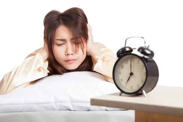 Asian woman covering ears with hands and alarm clock — Stock Photo, Image