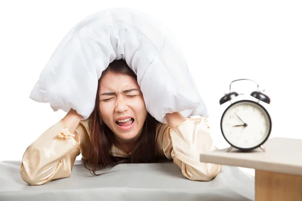 Sleepy Asian girl use pillow cover ears and alarm clock — Stock Photo, Image