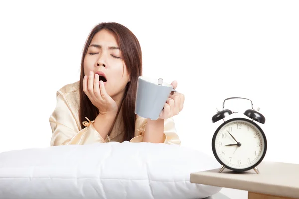 Chica asiática despierta, bostezo con despertador y taza de café — Foto de Stock