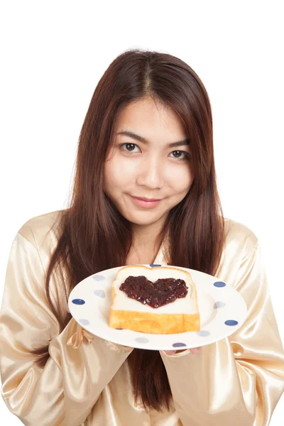 Mulher asiática em pijama com pão e coração forma berry jam — Fotografia de Stock