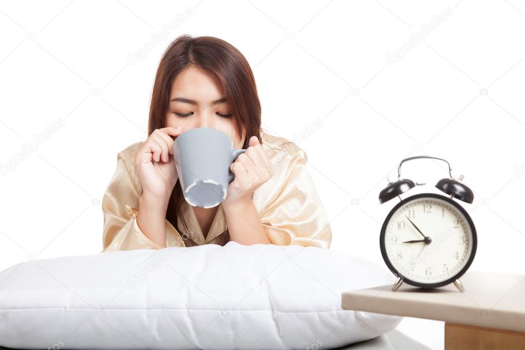 Happy Asian girl  wake up drink coffee with alarm clock