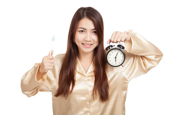 Asian woman in pajamas with toothbrush and clock — Stock Photo, Image