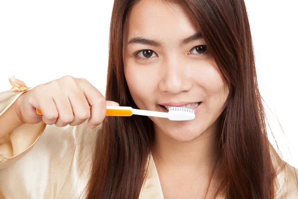 Mulher asiática de pijama limpa o dente com escova de dentes — Fotografia de Stock