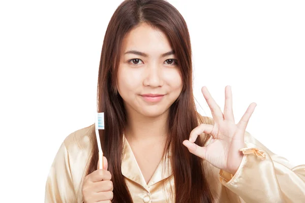 Mulher asiática em pijama mostrar OK com escova de dentes — Fotografia de Stock