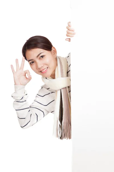 Asian girl with scarf peeking from behind blank sign show OK — Stock Photo, Image