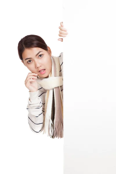 Beautiful Asian girl with scarf shocked, peeking from behind blank sign — Stock Photo, Image