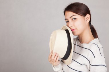 Güzel Asyalı kız tutun bir şapka kapat ağzını