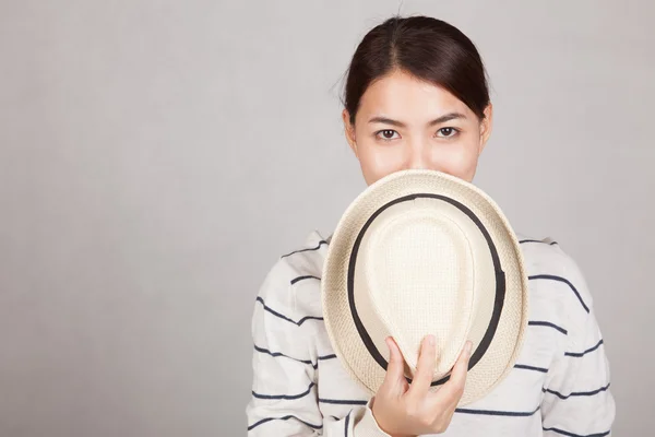 Schöne asiatische Mädchen halten einen Hut schließen ihren Mund — Stockfoto