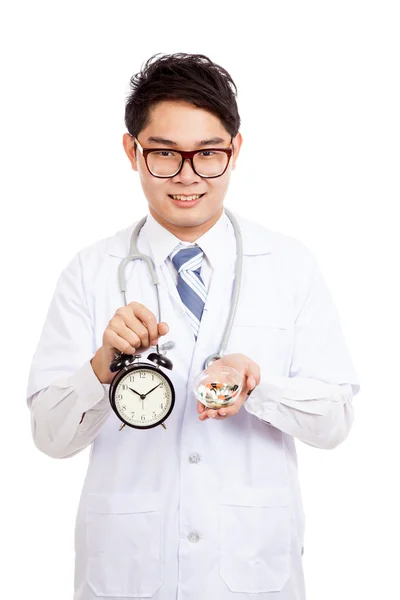 Asiatisk mannlig lege viser klokke og piller – stockfoto