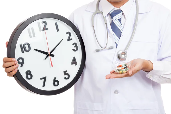 Asiático médico masculino mostrar um relógio e pílulas — Fotografia de Stock