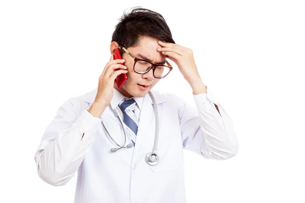 Aziatische mannelijke arts kreeg hoofdpijn praten op mobiele telefoon — Stockfoto