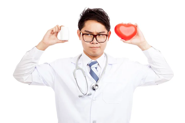 Asiático médico masculino pensar com coração vermelho e garrafa pílula — Fotografia de Stock