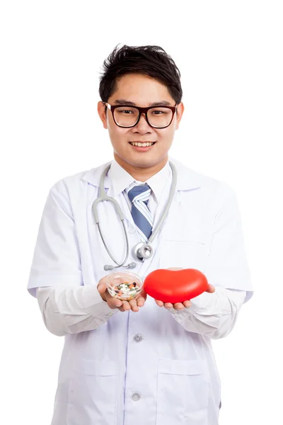 Asian male doctor with red heart and pills — Stock Photo, Image