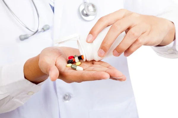 Asian male doctor with pills and pharmacy bottle — Stock Photo, Image