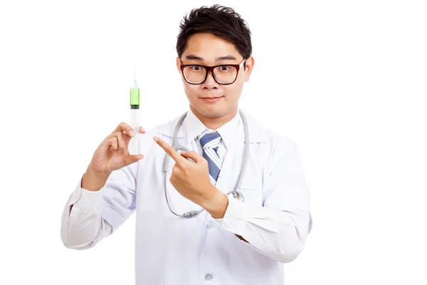 Азиатский врач указывает на шприц с зеленой медициной — стоковое фото