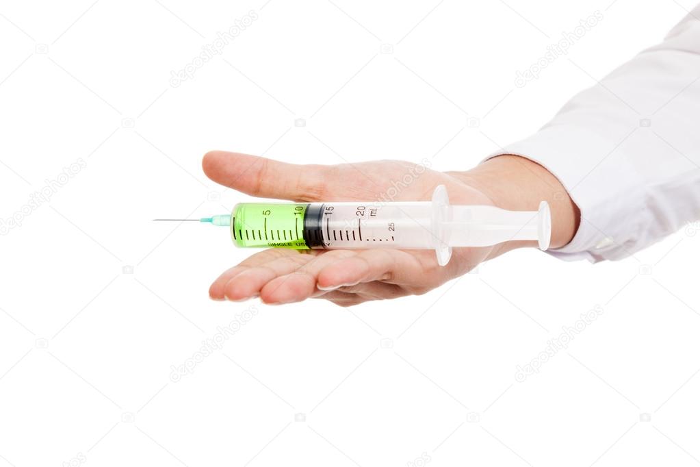 Close up of syringe with green medicine on palm hand