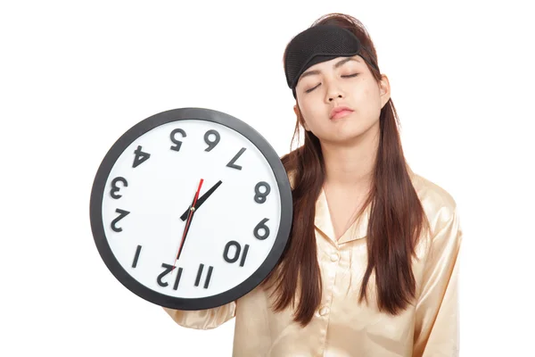 Sömnig asiatisk tjej med eye mask hålla en klocka upp och ner — Stockfoto