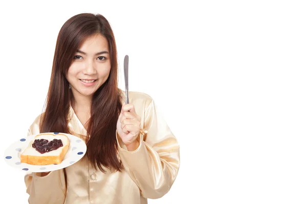 Asian woman in pajamas with bread and heart shape berry jam — Stock Photo, Image