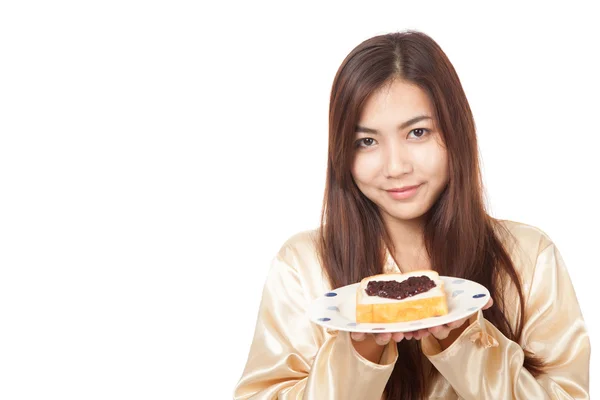 Asian woman in pajamas with bread and heart shape berry jam — Stock Photo, Image