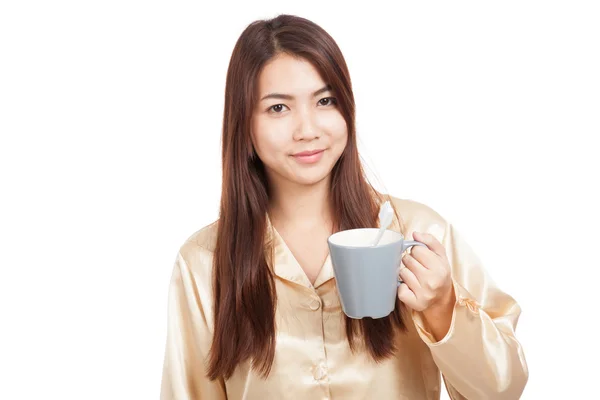 Asian woman in pajamas with toothbrush in mug — Stock Photo, Image