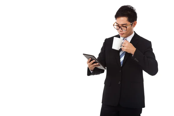 Empresário asiático com uma xícara de café e tablet PC — Fotografia de Stock