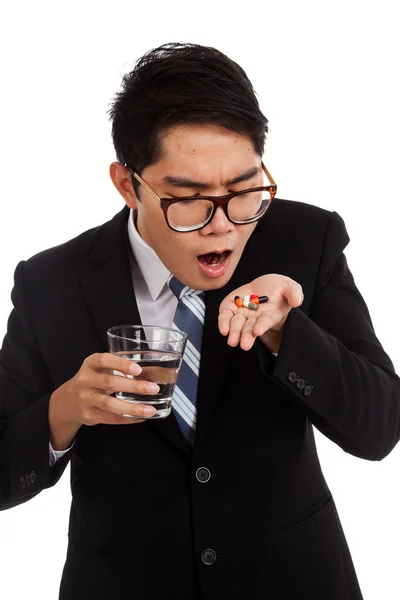 Uomo d'affari asiatico in procinto di mangiare medicina con un bicchiere d'acqua — Foto Stock