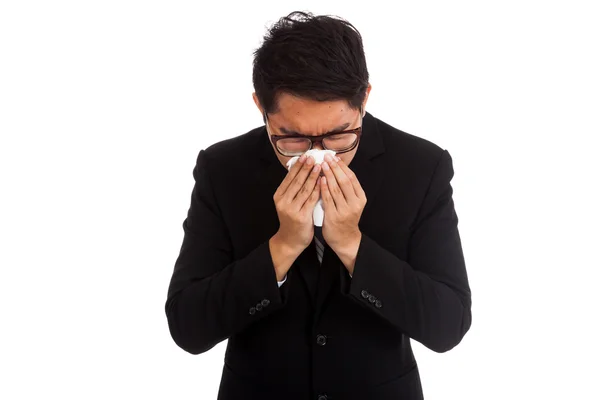 Asian businessman caught cold. Sneezing into tissue. — Stock Photo, Image