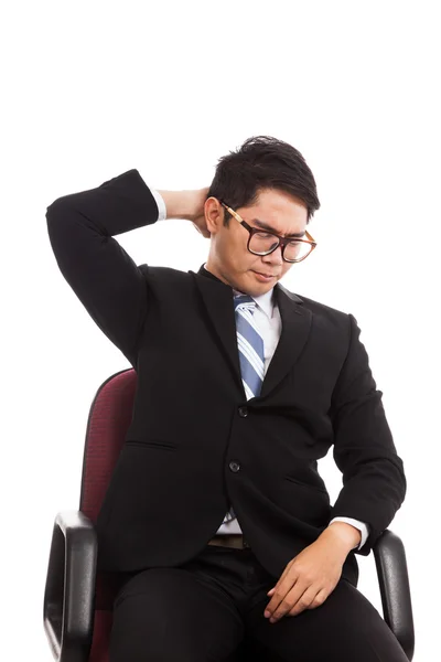 Asiatischer Geschäftsmann sitzt mit Nackenschmerzen auf Bürostuhl — Stockfoto