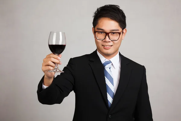 Asian businessman cheers with glass of red wine — Stock Photo, Image