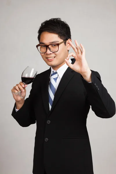 Asian businessman show OK with glass of red wine — Stock Photo, Image