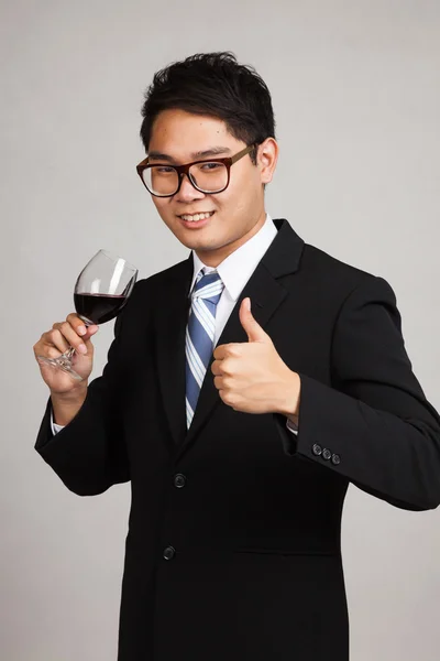 Asian businessman thumbs up with glass of red wine — Stock Photo, Image