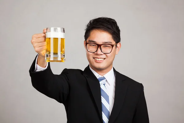Asian businessman cheers with mug of beer — Stock Photo, Image
