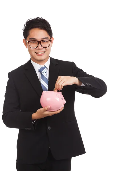 Asiático empresário sorriso colocar uma moeda para um rosa porquinho banco — Fotografia de Stock