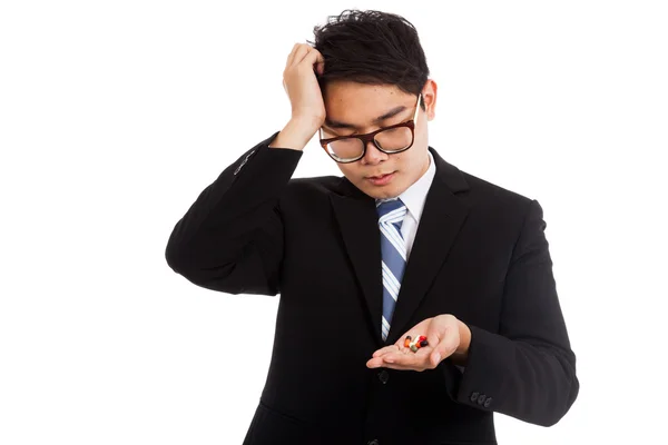 Asian businessman headache with medicine in his hand — Stock Photo, Image