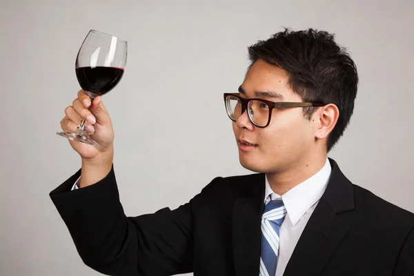 Asian businessman look at  red wine — Stock Photo, Image