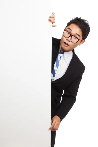 Asiático empresário choque espreitando por trás banner em branco — Fotografia de Stock