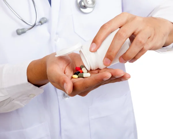 Asian male doctor with pills and pharmacy bottle — Stock Photo, Image