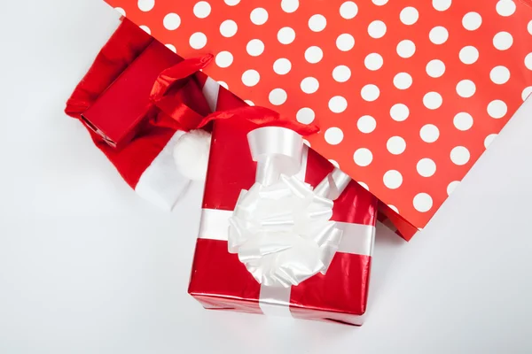 Cajas de regalo rojas y sombrero de Navidad en bolsas de compras —  Fotos de Stock